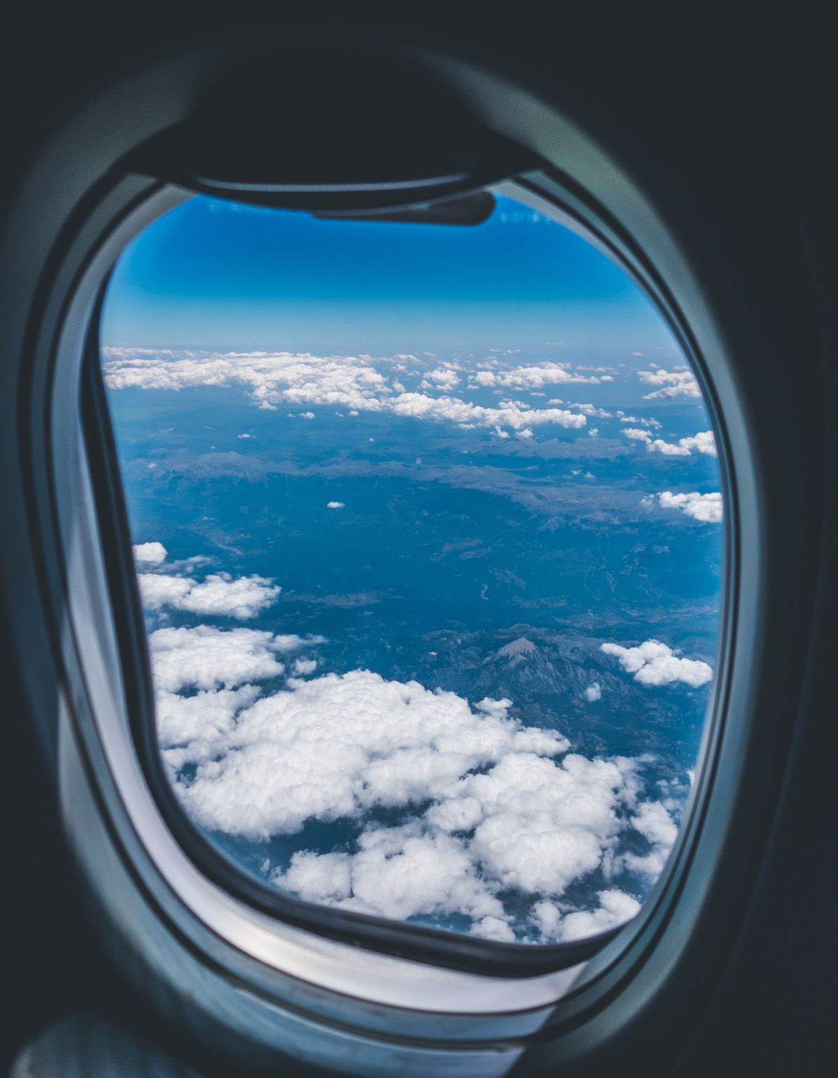 View from an airplane window above the clouds