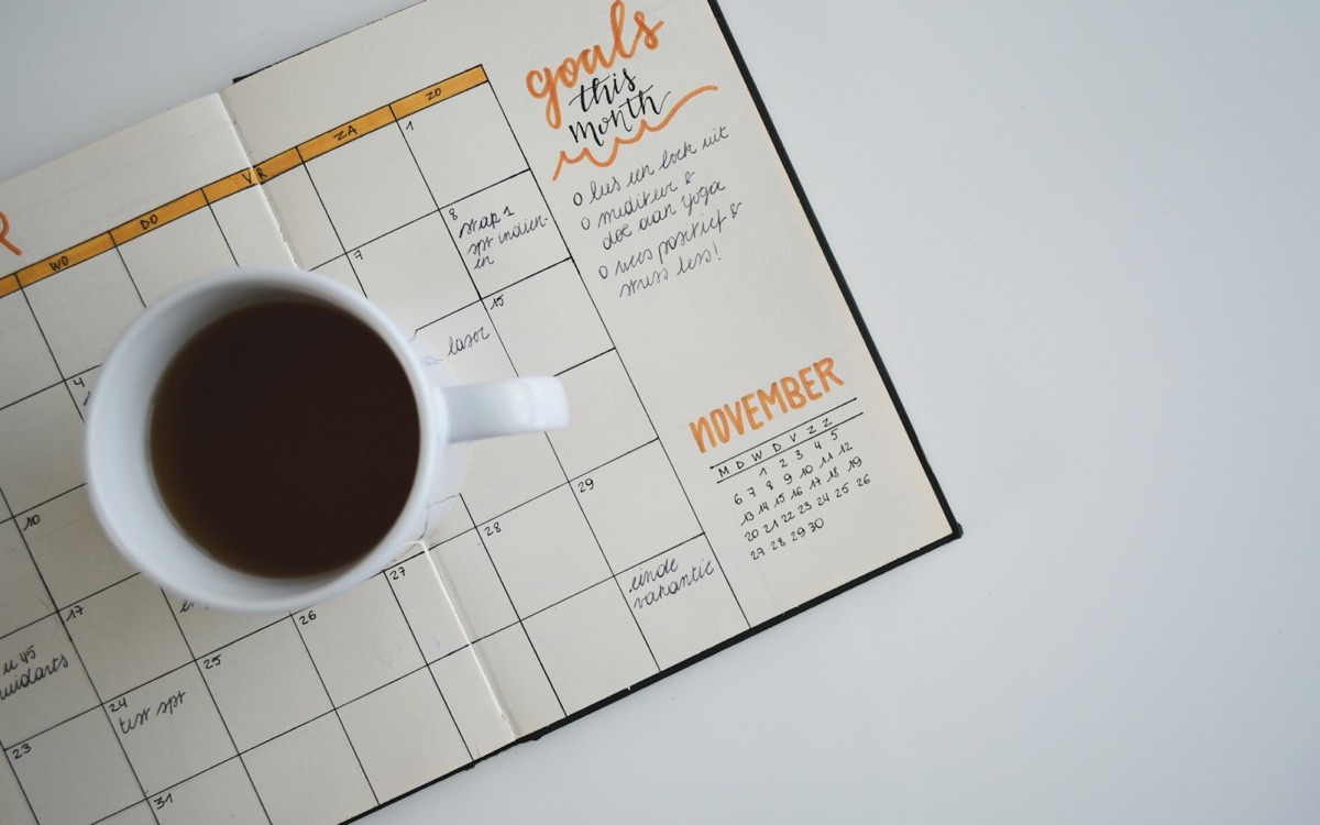 A morning coffee resting on an open monthly planner, care planned ahead